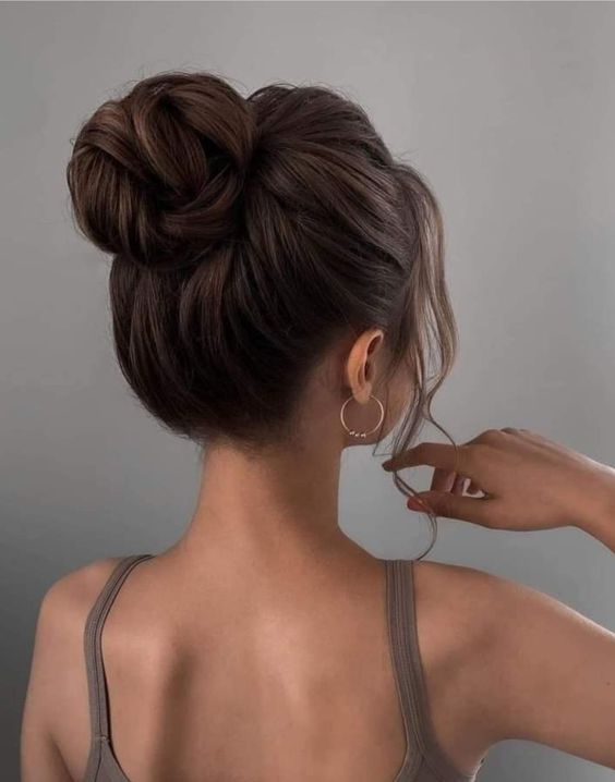 a classic twisted top knot with a bumpm on top and some locks down is a chic and catchy idea to try