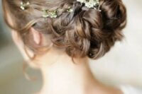 a classy curled low bun with a sleek volume on top and some waves down plus some fresh blooms is amazing