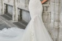 a creamy strapless corset wedding dress with lace appliques and a tulle tail with a train looks wow