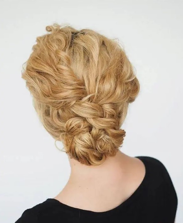 a curly double braided low bun is great for many bridal styles, from more romantic to boho ones
