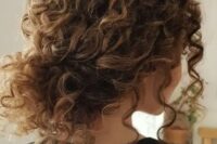 a curly messy low bun with bangs is a timeless idea for girls with curls – looks very pretty and relaxed