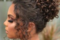 a curly top knot with some curls framing the face is a dreamy idea for a wedding