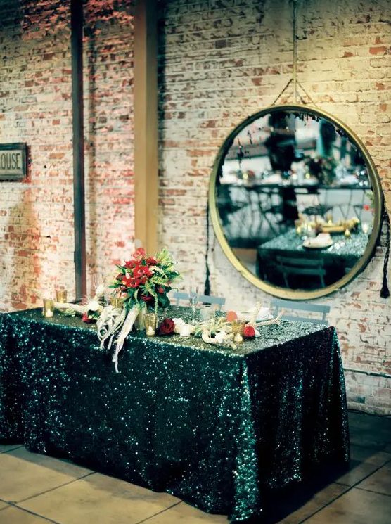 a dramatic tablescape with a black sequin tablecloth and burgundy blooms is a great idea for a moody wedding