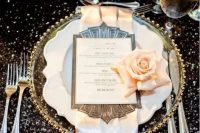 a glitz and glam 1920s tablescape with a black sequin tablecloth, a gold rim charger, neutral napkins and blush roses