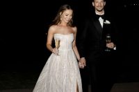 a gorgeous lace embellished strapless wedding dress with a slit and a train is a chic and glam solution for your wedding