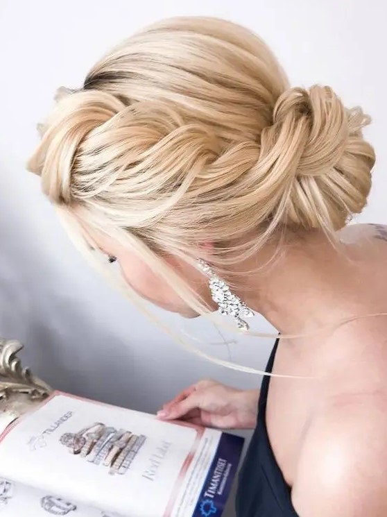 a large sided braided updo with a low bun and some locks down is super chic and refined