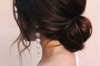 a loose low bun with a volume on top and some wavy locks down is a chic and beautiful idea for a modern bride