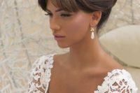 a lovely top knot with a braid and a bump plus bottleneck bangs is amazing for a glam bridal look