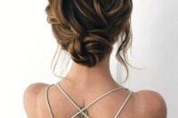 a lovely twisted wedding low bun with a braided twisted top and some locks framing the face is a chic and cool idea