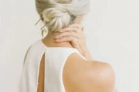 a low bun with a bump and an oversized gilded accessory is ideal for a minimalist bride