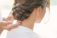 a low twisted and braided bun with a sleek top looks very elegant and chic and will catch an eye with braided touches