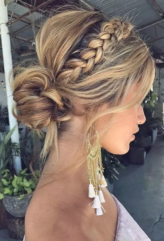 a messy boho low bun with a messy volume on top, a braided halo, some locks down looks very stylish and bold
