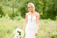 a modern strapless mermaid wedding dress with a covered plunging neckline, a train is a more modern version of classic mermaid gowns