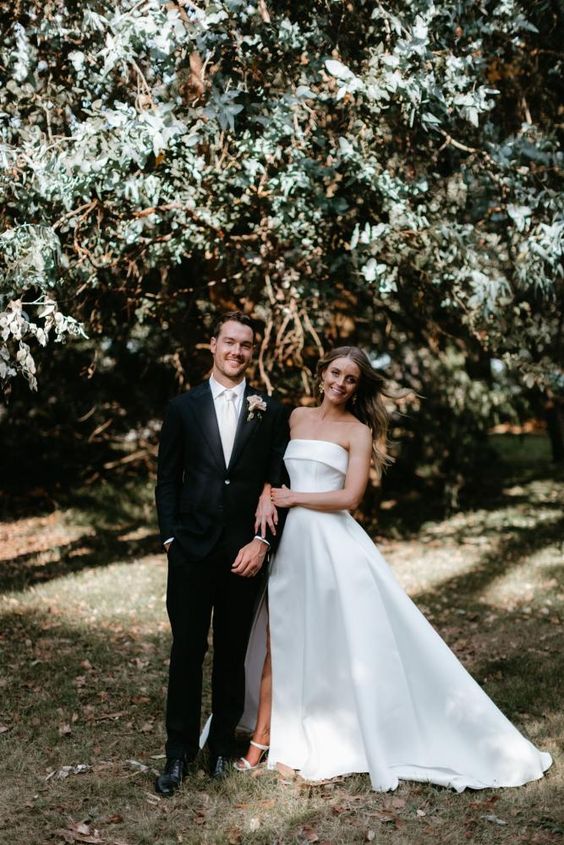 a modern strapless wedding ballgown with a thigh high slit and a train and white shoes are a perfect modern combo for a wedding