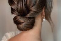 a refined and formal wedding low bun with a twisted top and bun, with face-framing locks is beautiful