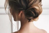 a romantic twisted low bun with much volume and texture on top plus some locks down is elegant
