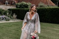 a silver sequin wedding dress with a deep neckline, wide sleeves and sheer parts plus silver shoes