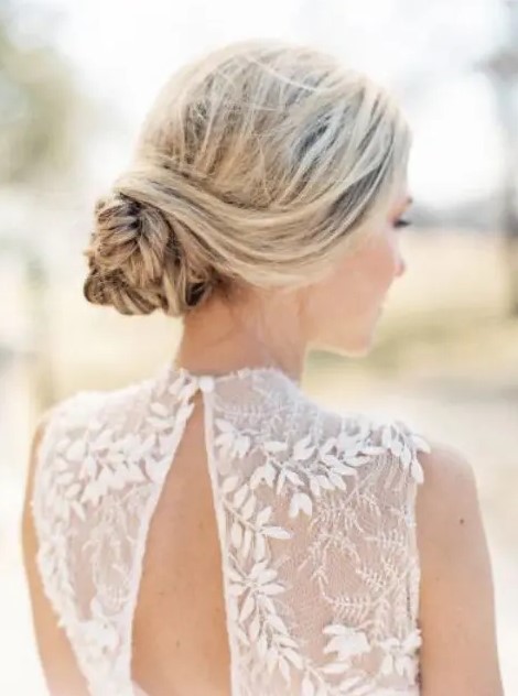 a simple boho wedding hairstyle with a braided low bun and twists is a timeless solution for a Scandinavian bride