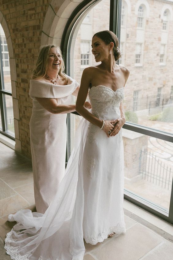a strapless embellished wedding dress with a lace trim and a long veil is a beautiful solution for a modern romantic bride
