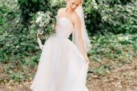 a strapless wedding ballgown with a layered skirt with a train and a veil for a vineyard princess