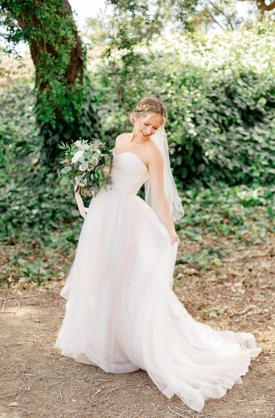 a strapless wedding ballgown with a layered skirt with a train and a veil for a vineyard princess