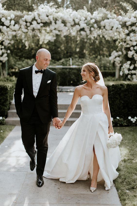 a strapless wedding ballgown with a sweetheart neckline, a pleated skirt with a front slit and embellished shoes for a formal wedding