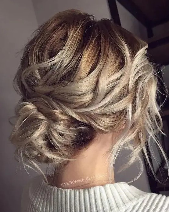 a super messy and wavy low bun with a bump and some locks down for a effortless look