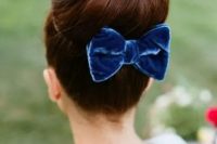 a top knot accessorized with a velvet bow is a classic idea to try for a retro-inspired or Christmas wedding