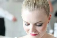 a top knot with a braided element and a sleek top is a lovely and chic idea for a modern and refined bride