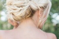 a twisted and messy low bun with some locks down for a chic and elegant look at the wedding