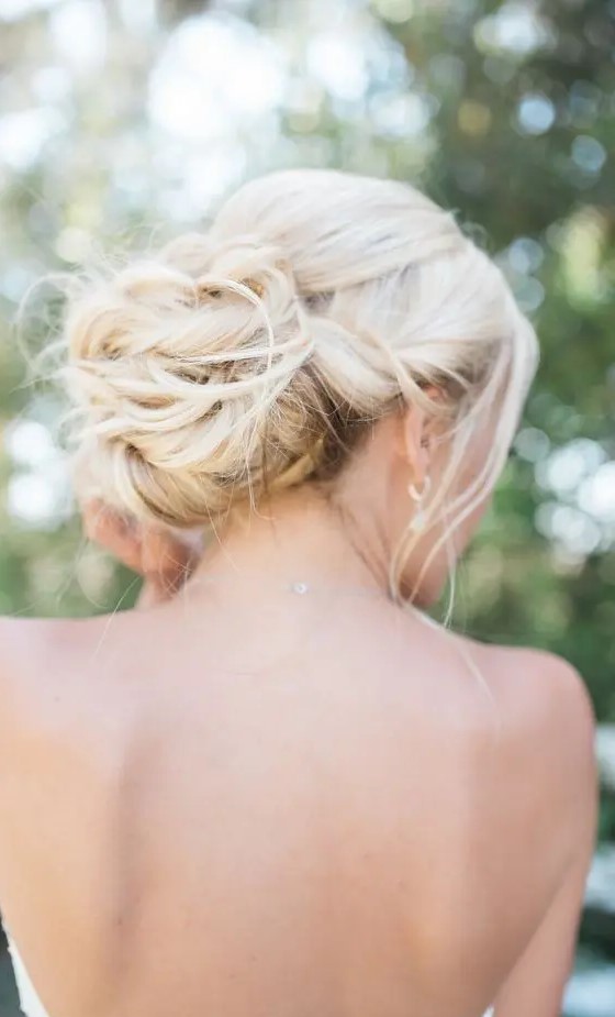 a twisted and messy low bun with some locks down for a chic and elegant look at the wedding