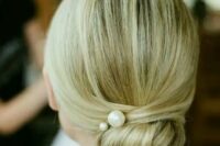 a twisted low bun with pearl pins and a sleek top for a modern take on a traditional look
