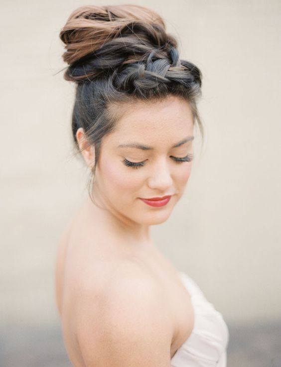 a unique wedding hairstyle that consists of a braided top and a braid wrapped around the top knot is all cool