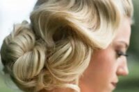 a vintage wavy low updo with a large bun and some locks down for ultimate elegance