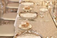 a white sequin tablecloth, clear chargers, silver cutlery and mini donuts as favors for a chic and glam wedding