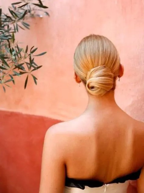 an elegant sleek low bun with a twist is a chic idea and will bring a elegant flavor to your modern bridal look