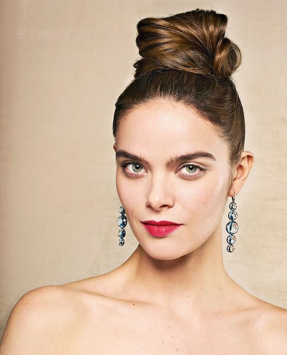 an elegant top knot with a sleek top and a messy swirled top knot for a chic and effortlessly cool look