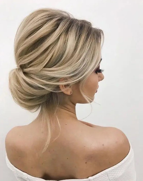 an elegant twisted low bun with a volume on top and some locks down is a timelessly chic and cool hair idea
