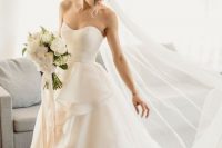 an elegant wedding ballgown with a sweetheart neckline and ruffles on the skirt plus a train
