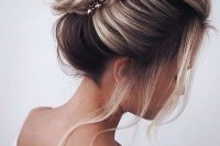 an elegant wrapped top knot with a bump on top, face-framing hair and lovely rhinestone accents
