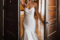 an exquisite modern strapless wedding dress with a mermaid silhouette, a draped bodice and a train is jaw-dropping