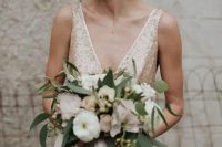 champagne-colored wedding dress with wide straps, a deep V cut and gold sequin, a plain skirt