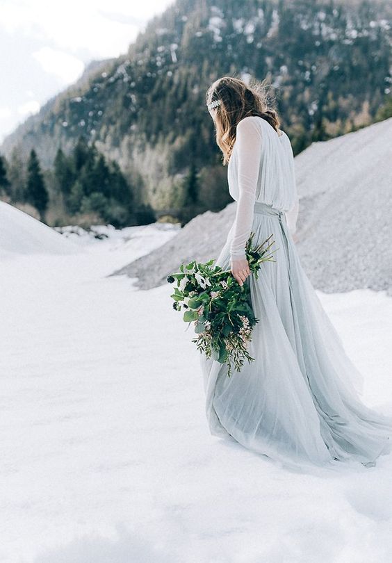 a light grey wedding gown with an airy skirt and bodice, long sleeves and a bejeweled crown for a modern winter Nordic look