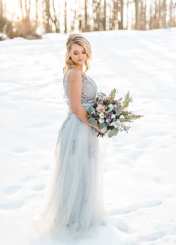 a show-stopping powder blue A-line wedding gown with a lace bodice and a layered skirt, no sleeves and a V-neckline