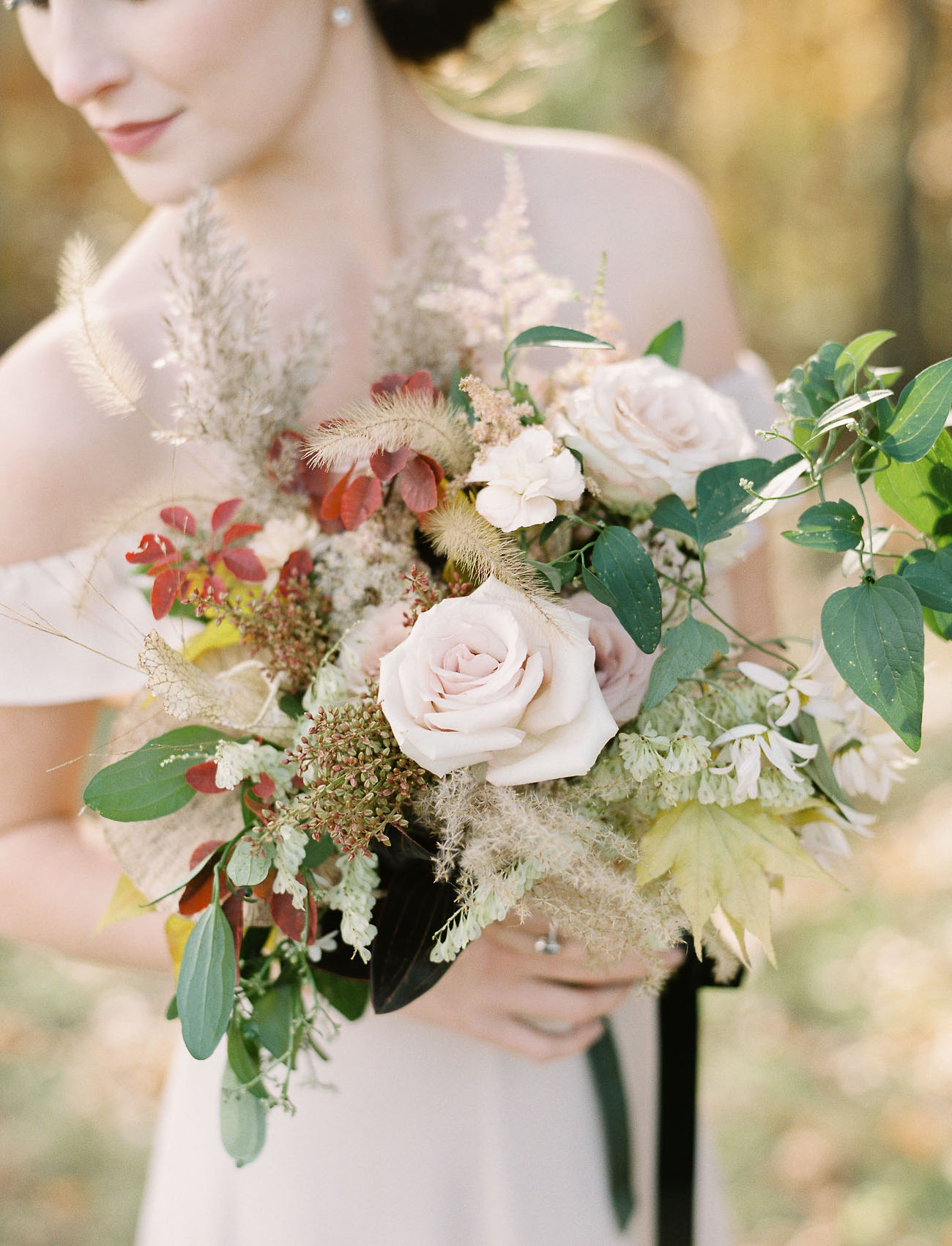 Her bouquet included both creamy hues and burgundy ones plus greenery and dried herbs