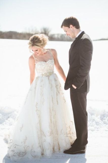 a gorgeous sleeveless A-line wedding gown with an illusion neckline and gold lace for a statement