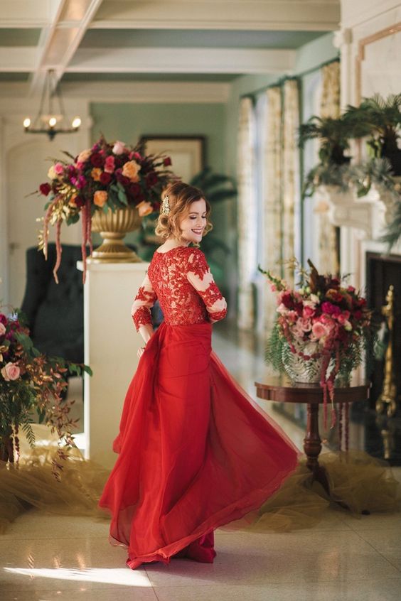 a red wedding gown with a lace illusion bodice and a plain layered skirt plus a high neckline and a rhinestone hairpiece
