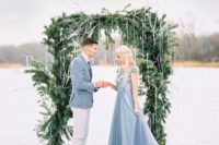 04 a beautiful winter wedding arch of evergreens with fake icicles hanging gown for a frozen feel