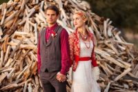 05 a bride wearing a vintage-inspired wedding gown with a red sash and a printed red cardigan, a groom wearing a grey suit and a plaid shirt