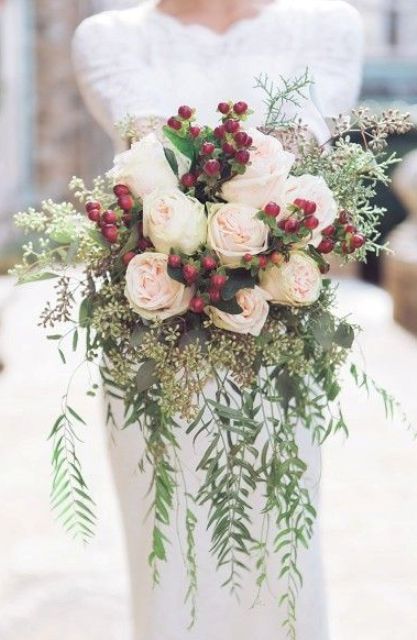 a holiday wedding bouquet with cascading greenery, blush roses, eucalyptus and holly berries